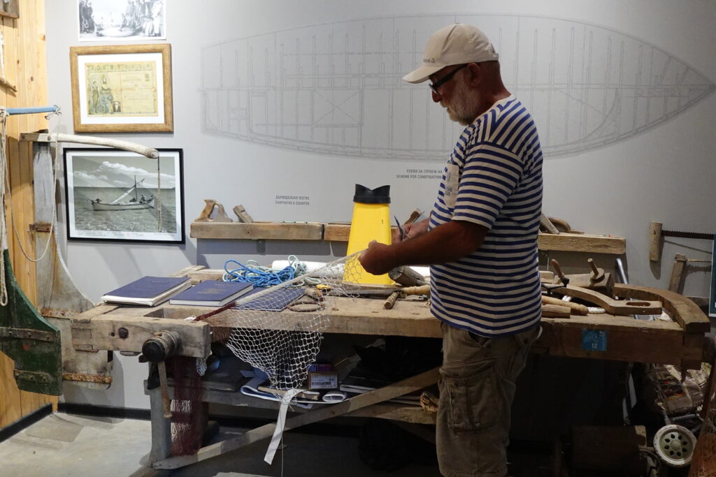 A man showing something at a work bench